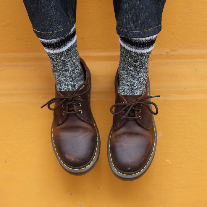 woman wearing black marl cotton socks against yellow wall