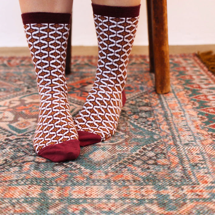 woman wearing tile print cotton socks on a patterned rug