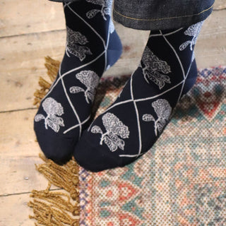 woman wearing floral patterned socks on a cosy rug