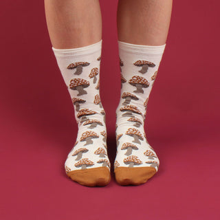 girl wearing mushroom patterned socks in cream and gold