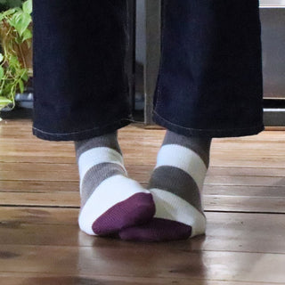 girl wearing striped wool socks on a wooden floor